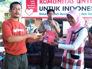 Ketua Komunitas Untuk Indonesia, Yusrizal KW, disaksikan Isra Iskandar (Pakar Penilai) , menyerahkan hadiah buku kepada Nila R Isna, sebagai penanggap terbaik dalam diskusi. (Foto Faiz)